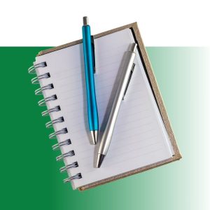 Collection of office supplies including various pens, pencils, notepads, sticky notes, and blu tack adhesive on green gradient background