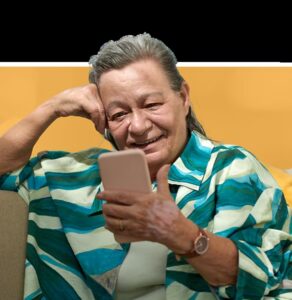 Woman smiling while holding a smartphone, representing digital access to employee assistance programs